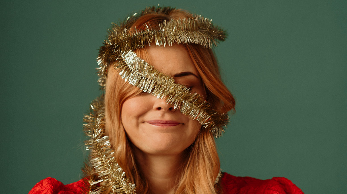 Vrouw met kerstboomslinger om haar hoofd - kerststress?