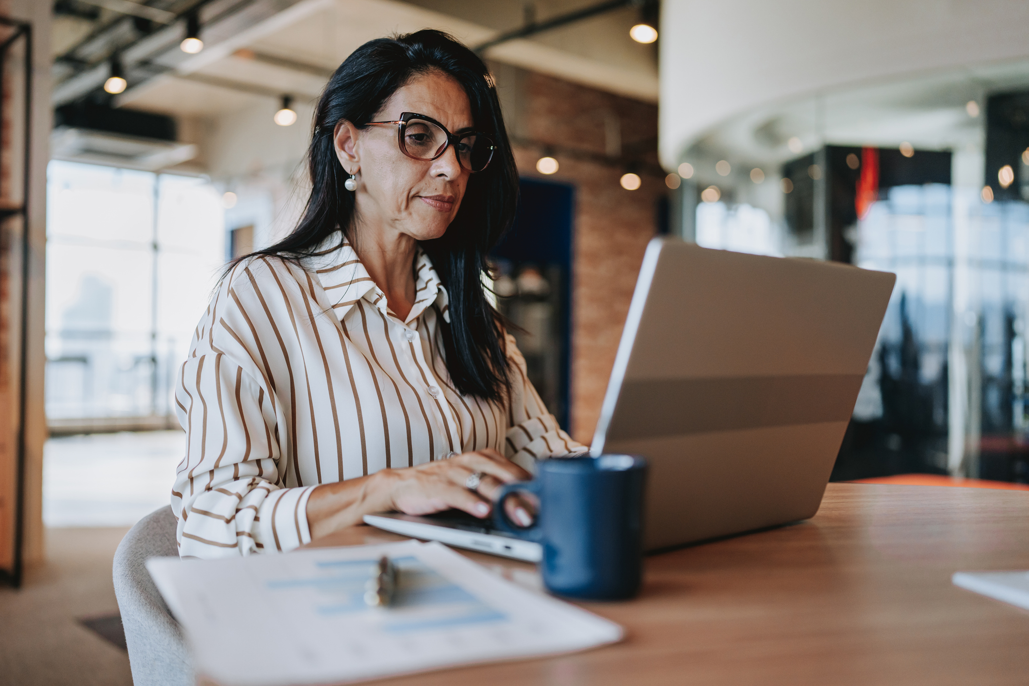 Oudere dame is bezig op haar laptop op kantoor