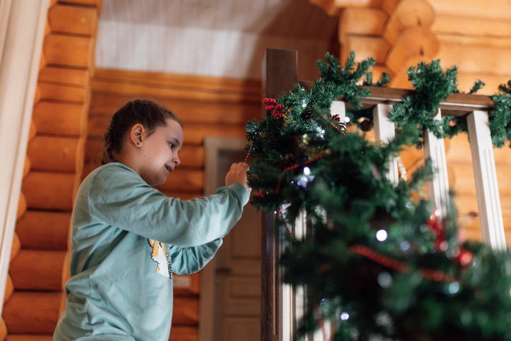 Vrouw is bezig de kerstboom te versieren