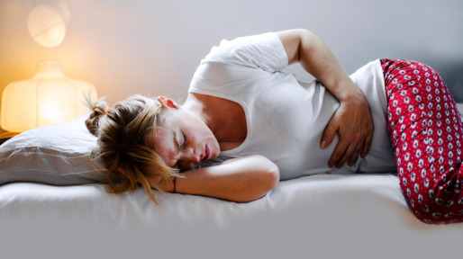 Vrouw met buikpijn in bed