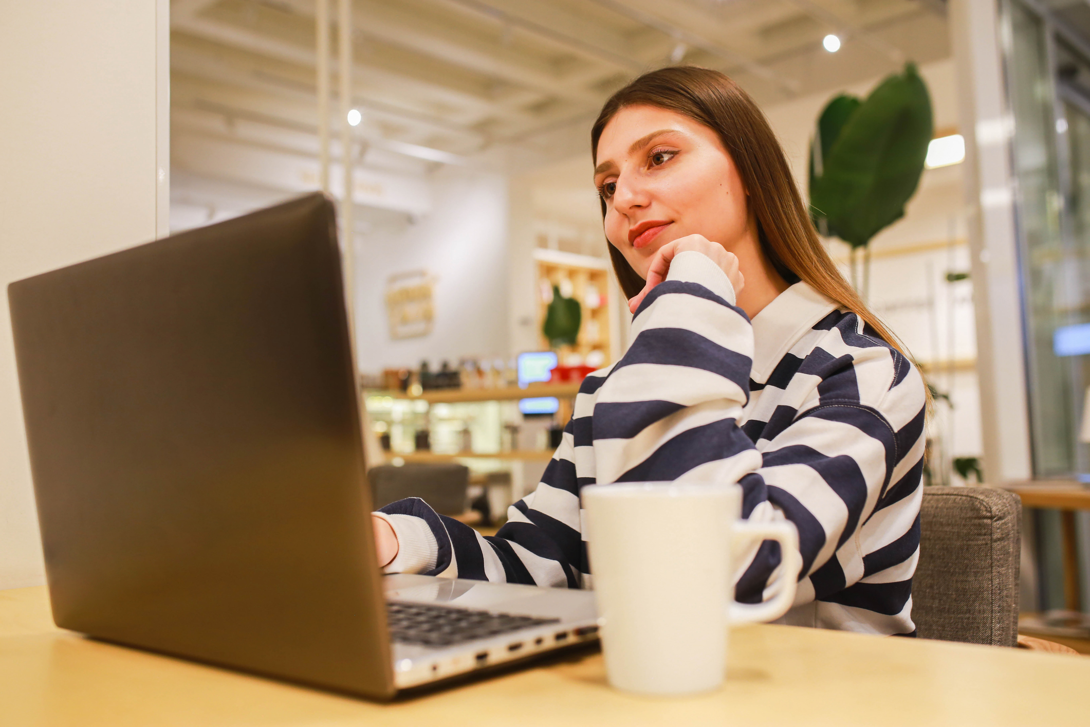 Blanke vrouw met bruin haar achter haar laptop