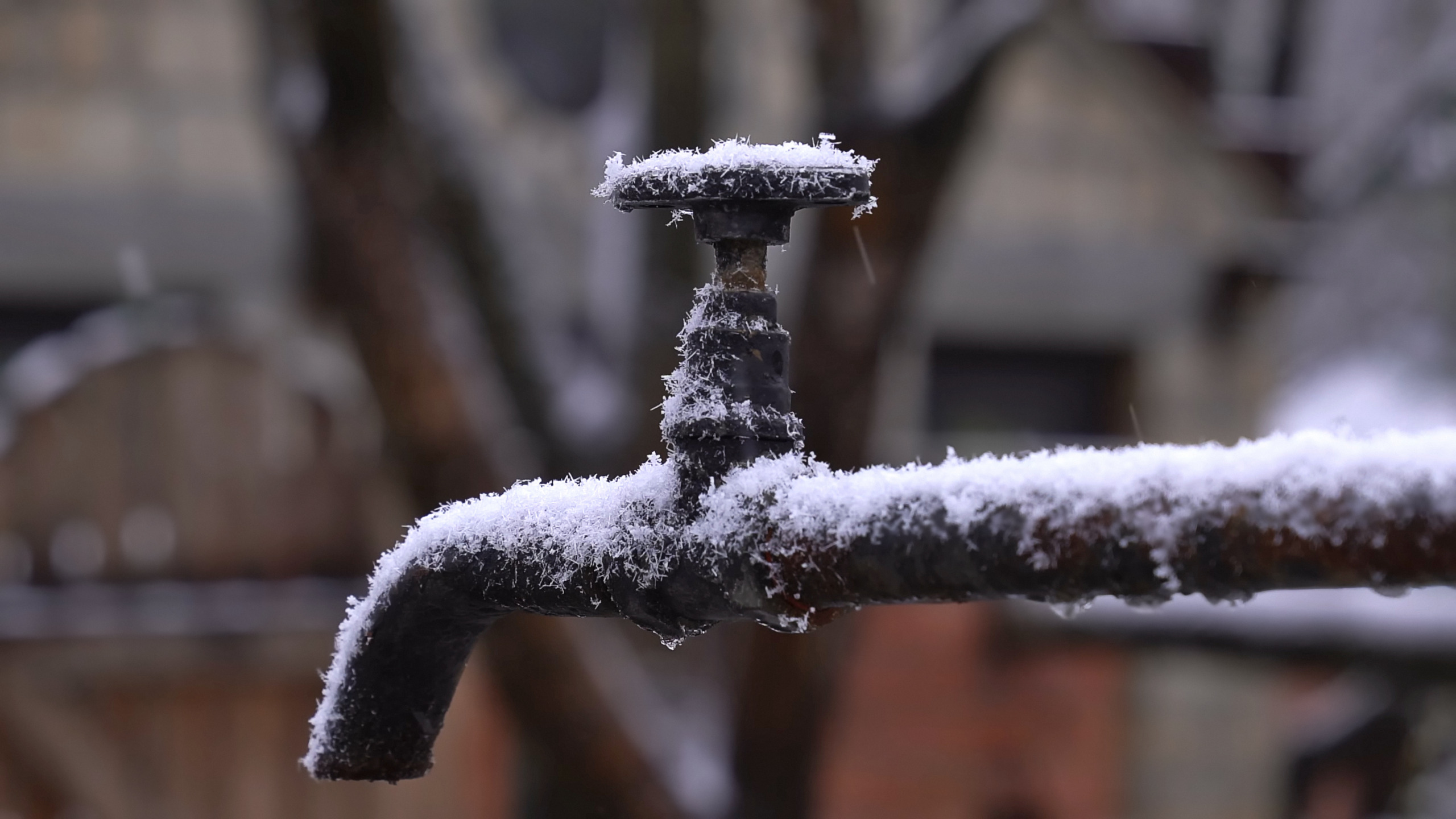 Bevroren buitenkraan in de winter, met ijs op de kraan