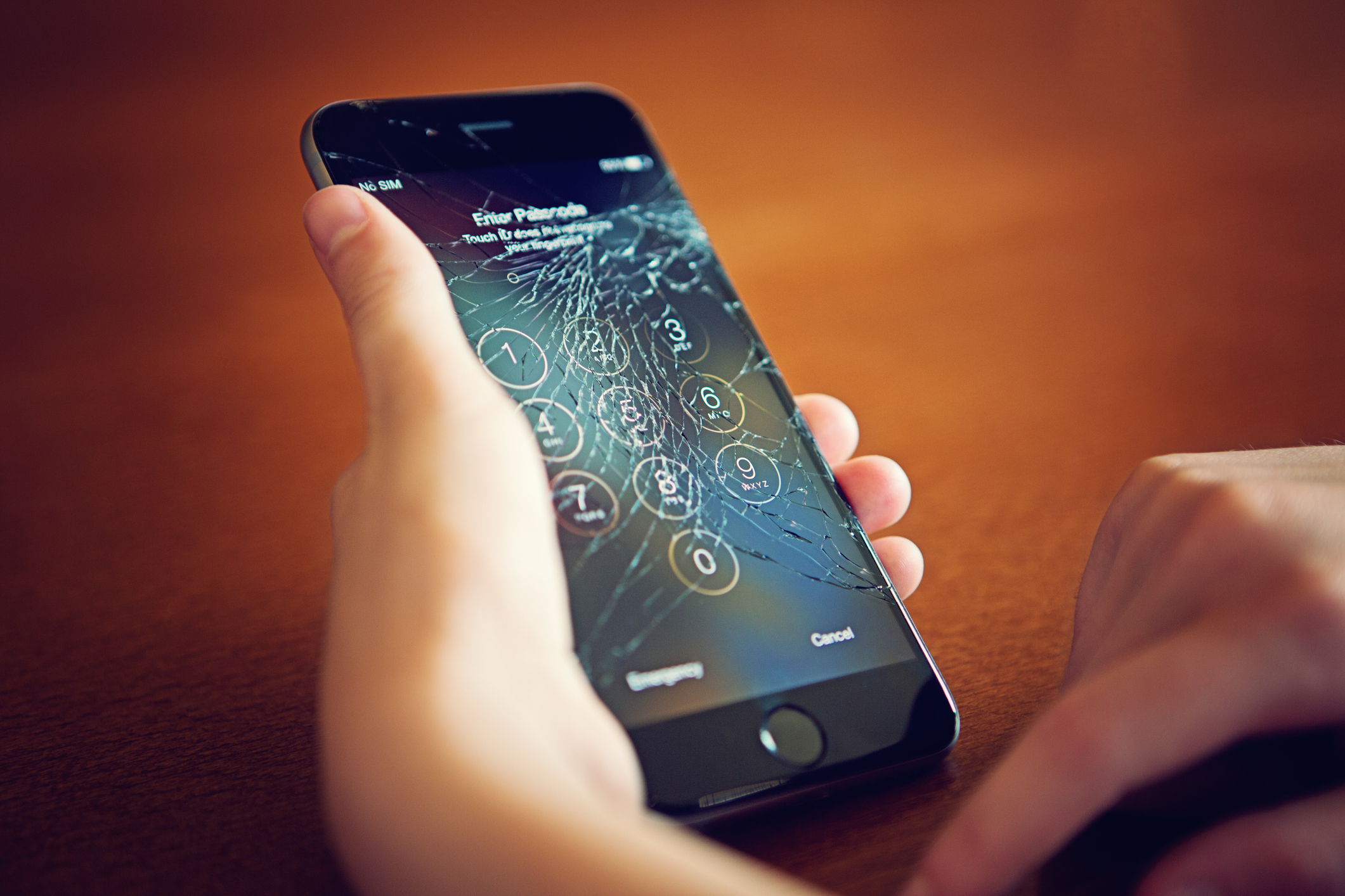 Smartphone met gebarsten scherm in vrouwenhand