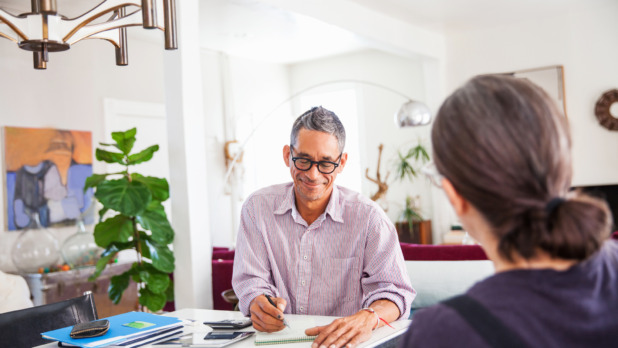 Man en vrouw zijn thuis bezig met papierwerk aan bureau