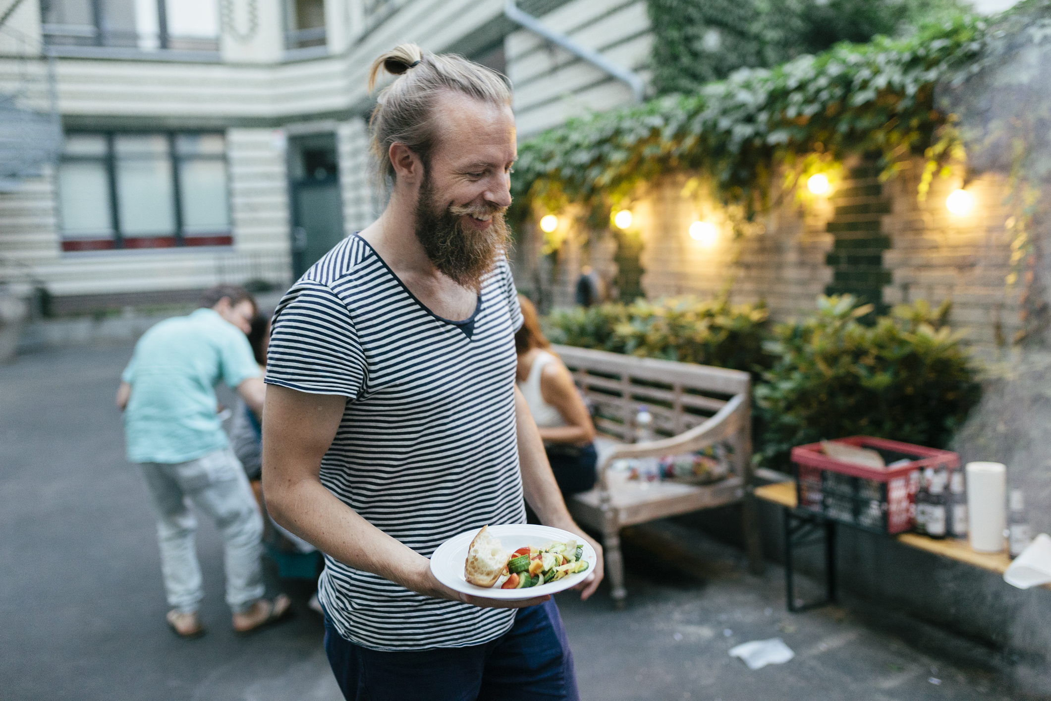 Hippie met man-bun lacht op een vegan barbecue