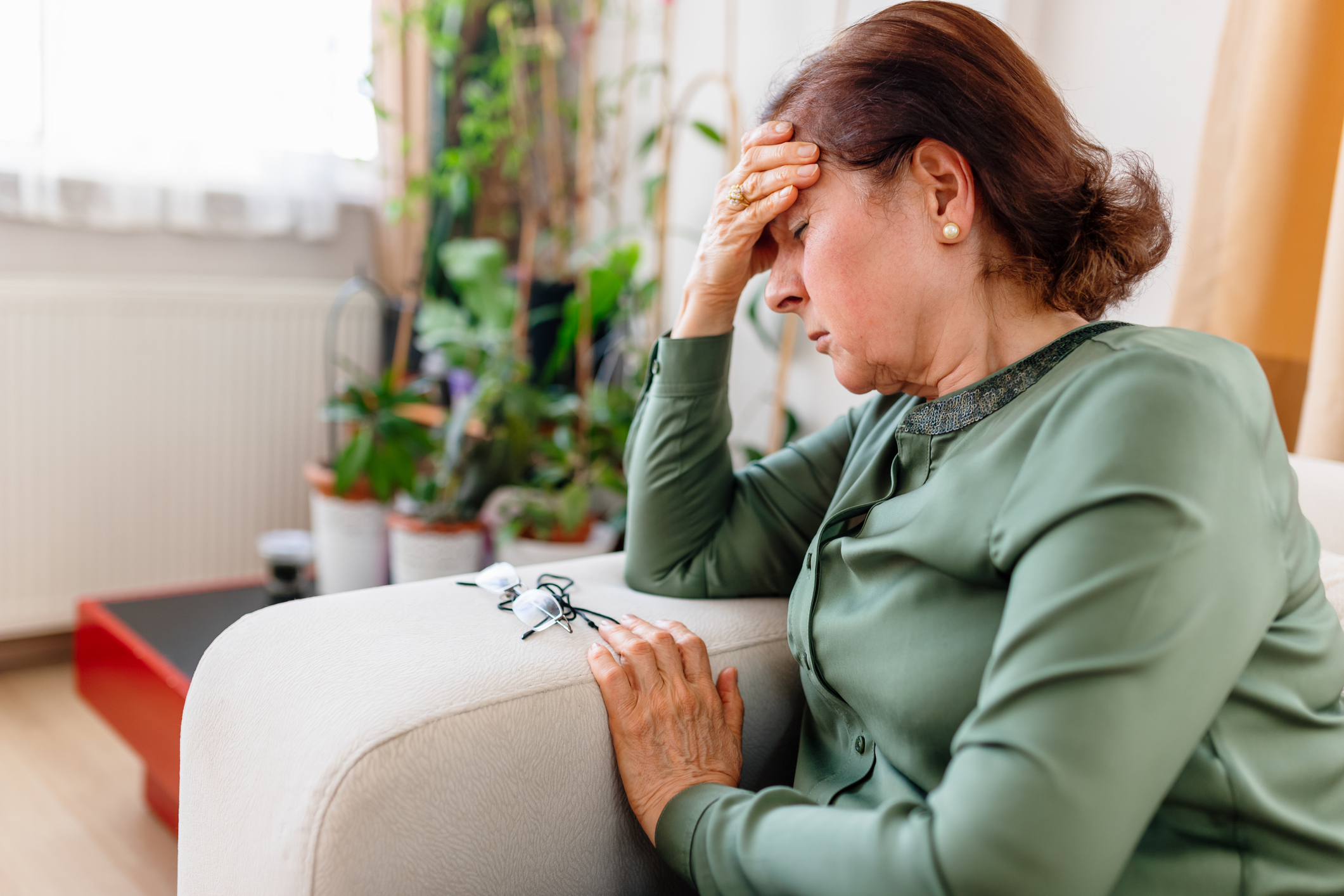 Vrouw heeft last van duizeligheid, zit op de bank