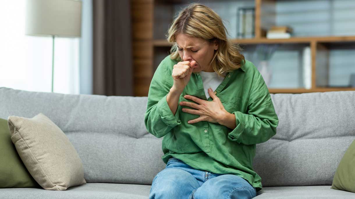 hoestende vrouw op de bank