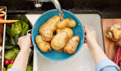 Aardappelen worden gewassen onder de kraan