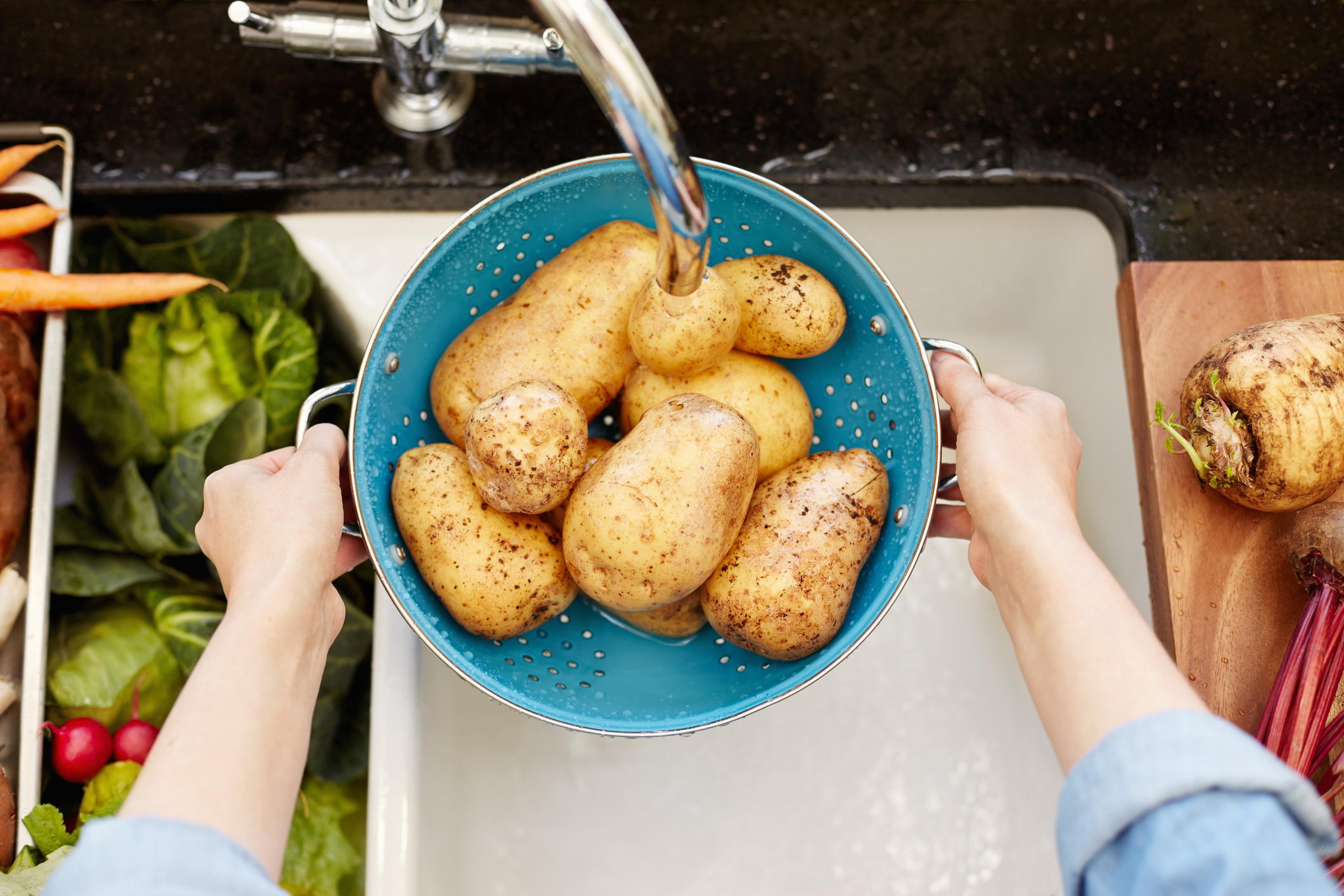 Aardappelen worden gewassen onder de kraan