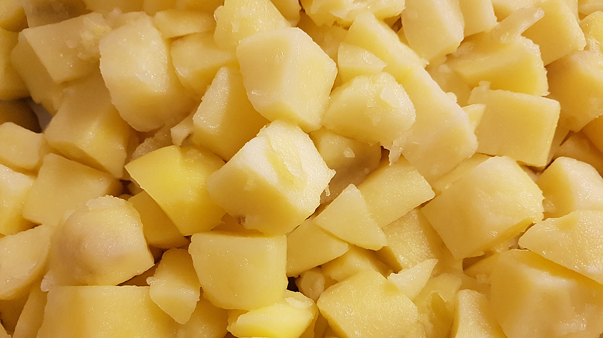 Afgekoelde gekookte aardappelen in partjes gesneden