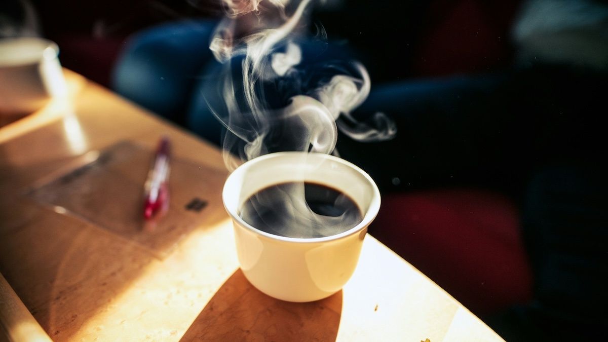 Een kop koffie op tafel in de zon