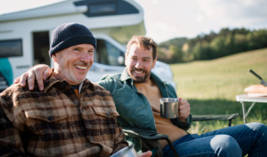 Vader en zoon zitten voor een camper