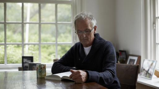 Senior man reading book in cottage