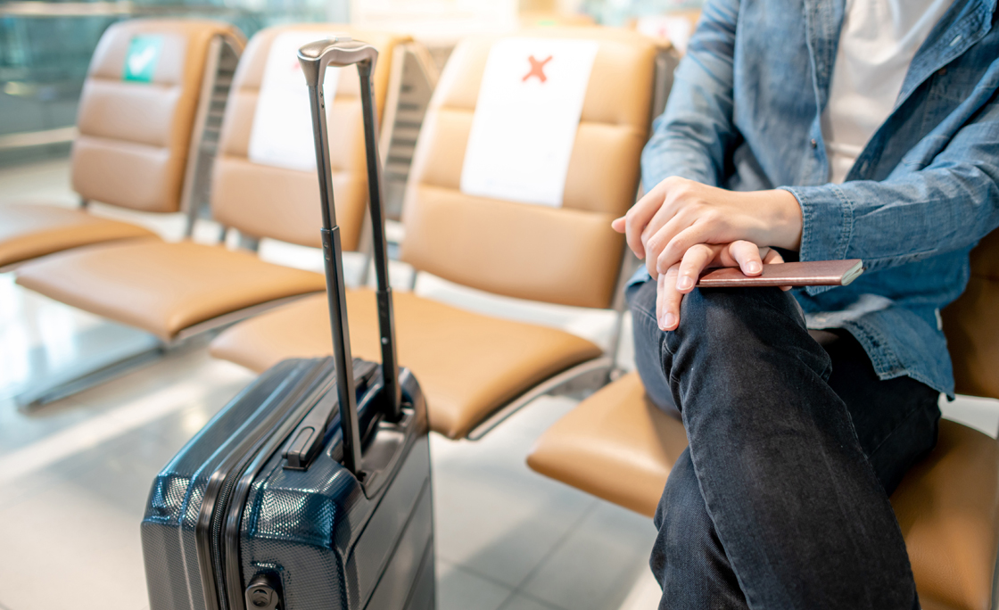 Tourist sitting with suitcase in airport terminal