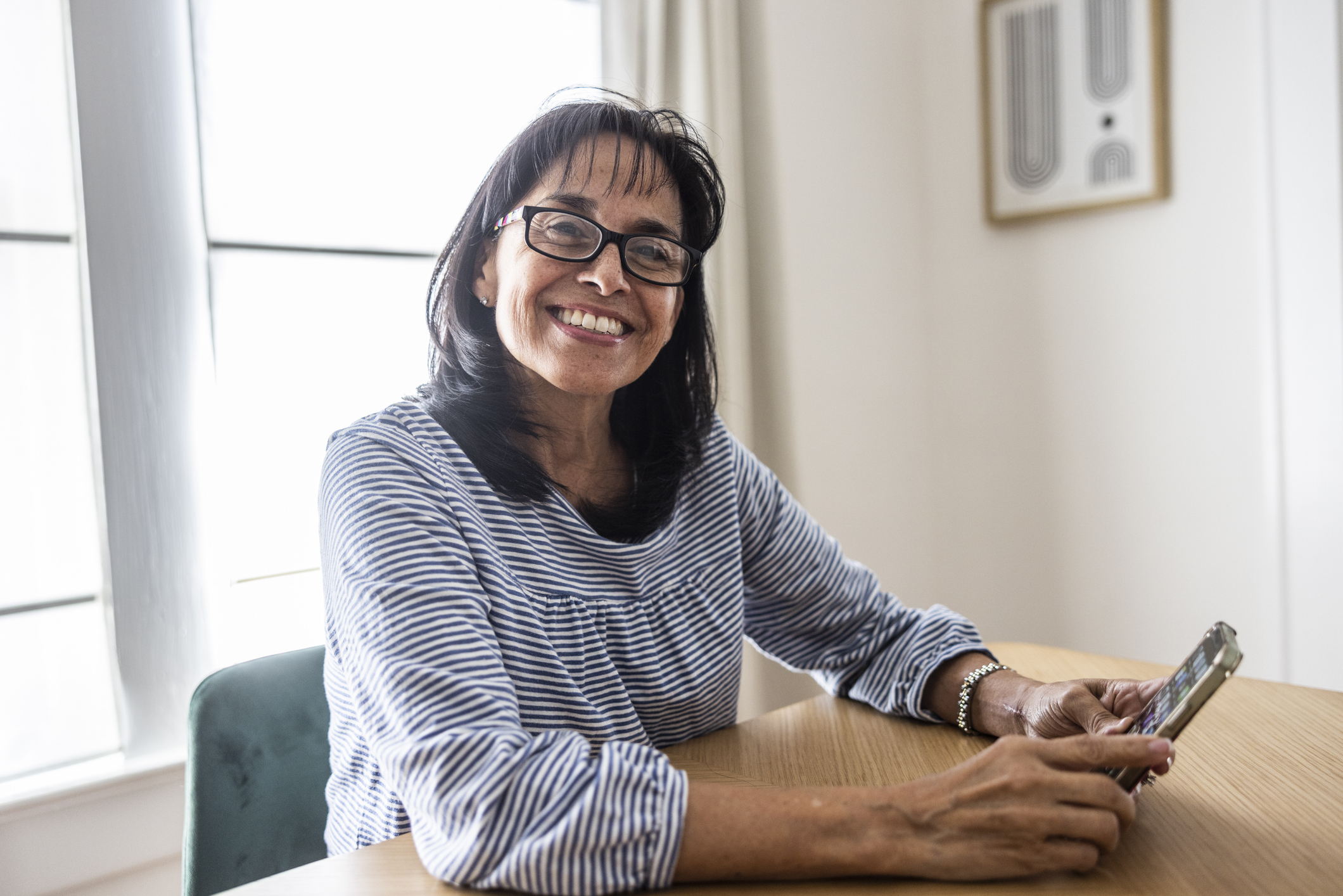 Dame met smartphone in de hand, grijnzend