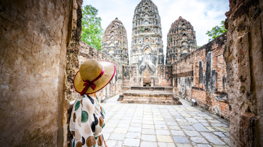 Vrouw kijkt bewonderend naar tempel in Thailand