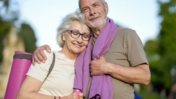 Man en vrouw doen samen aan hardlopen, poseren met handdoek