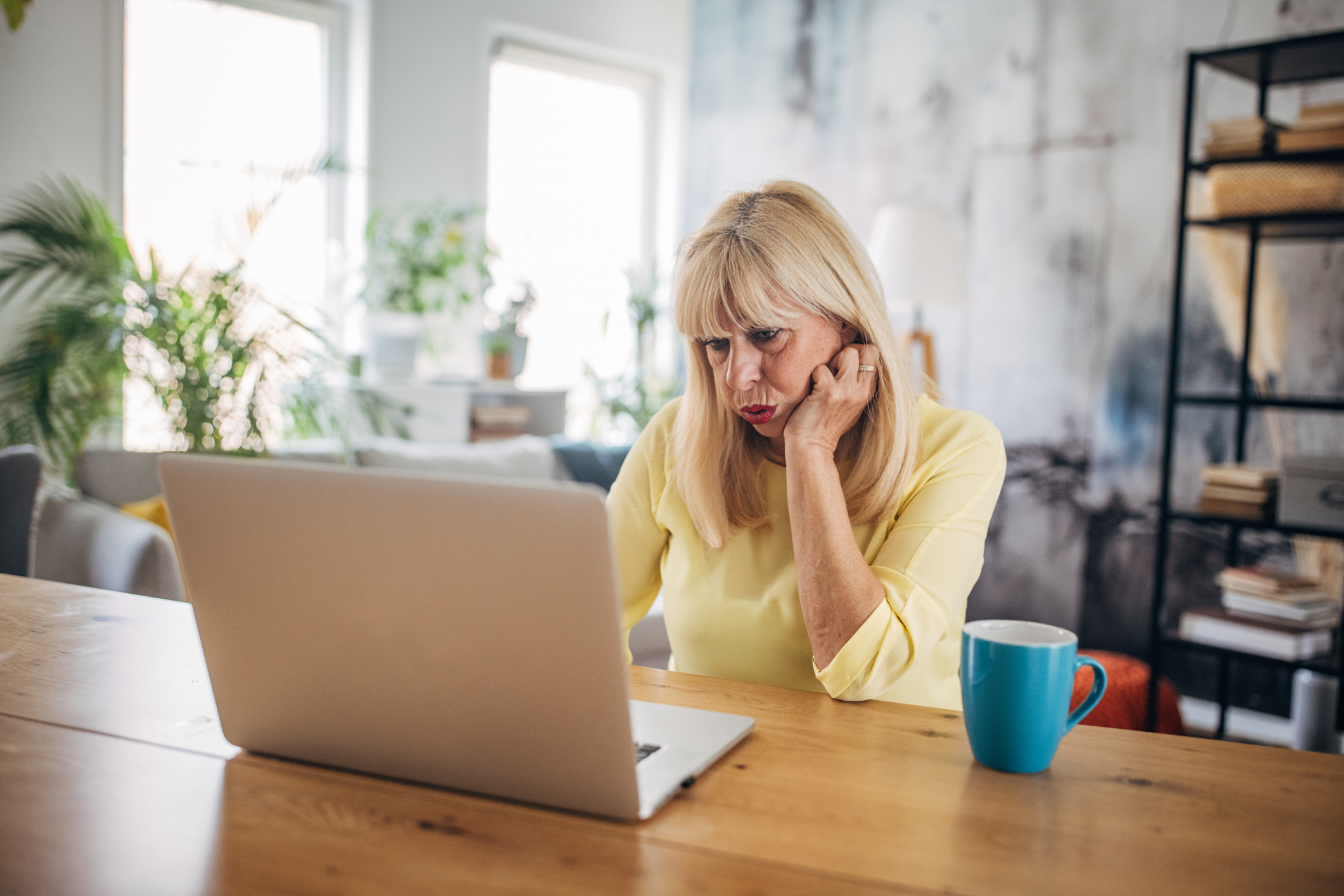 Vrouw kijkt bezorgd op laptop