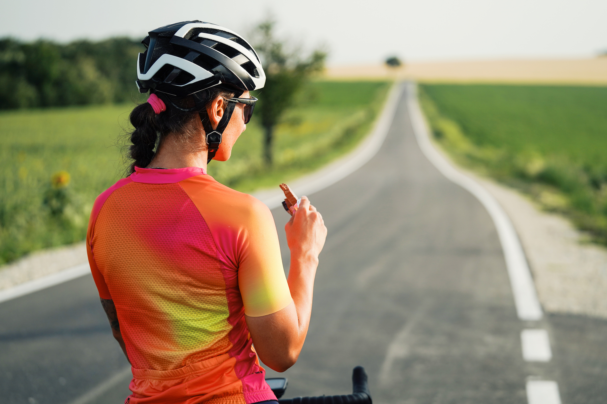 Racefietser neemt een hap van een chocolade bar