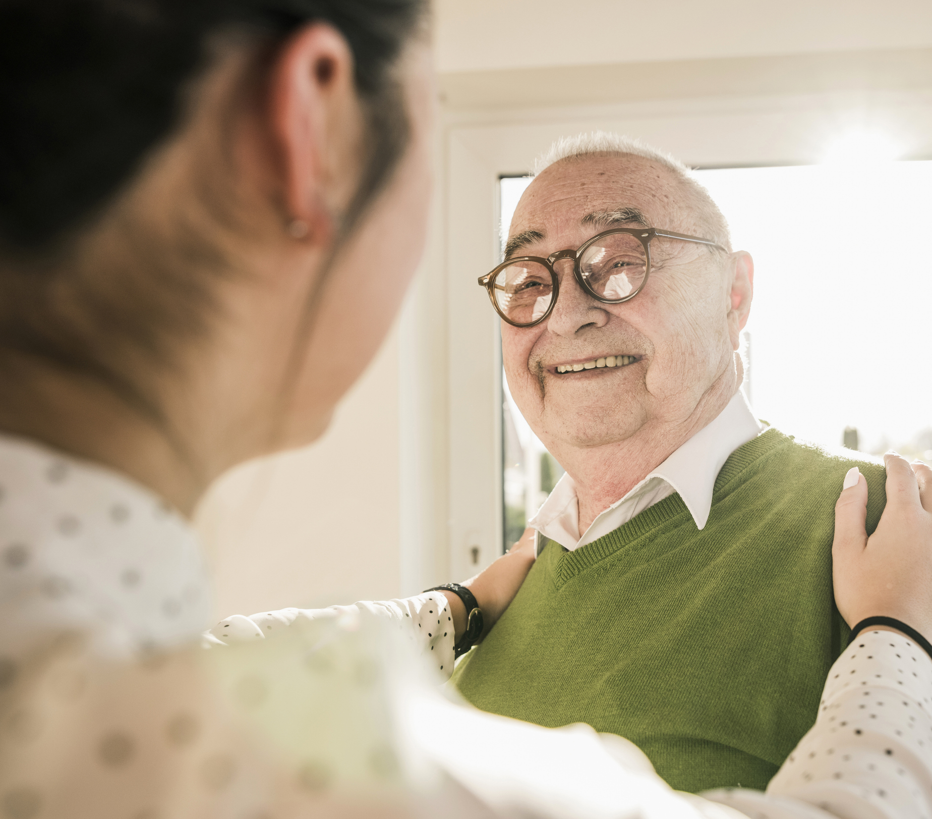 Oudere man in gesprek met jongere verzorgster