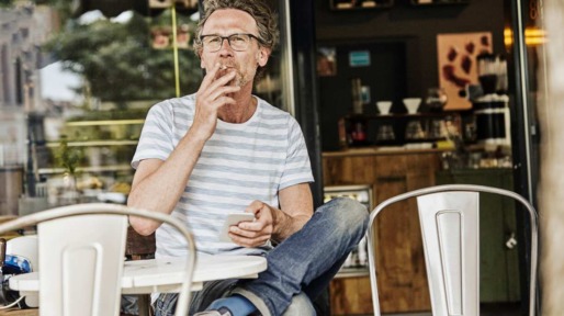 Man rookt sigaret op terras