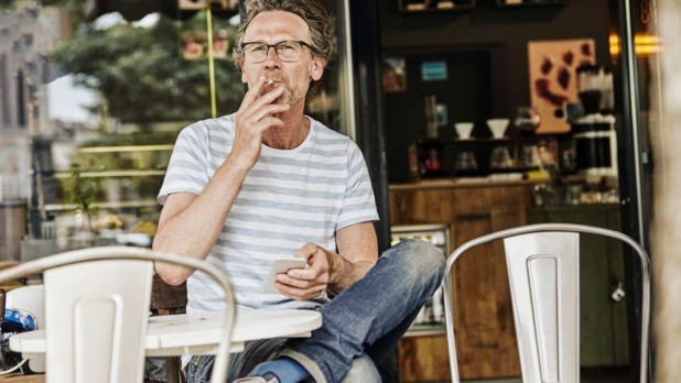 Man rookt sigaret op terras