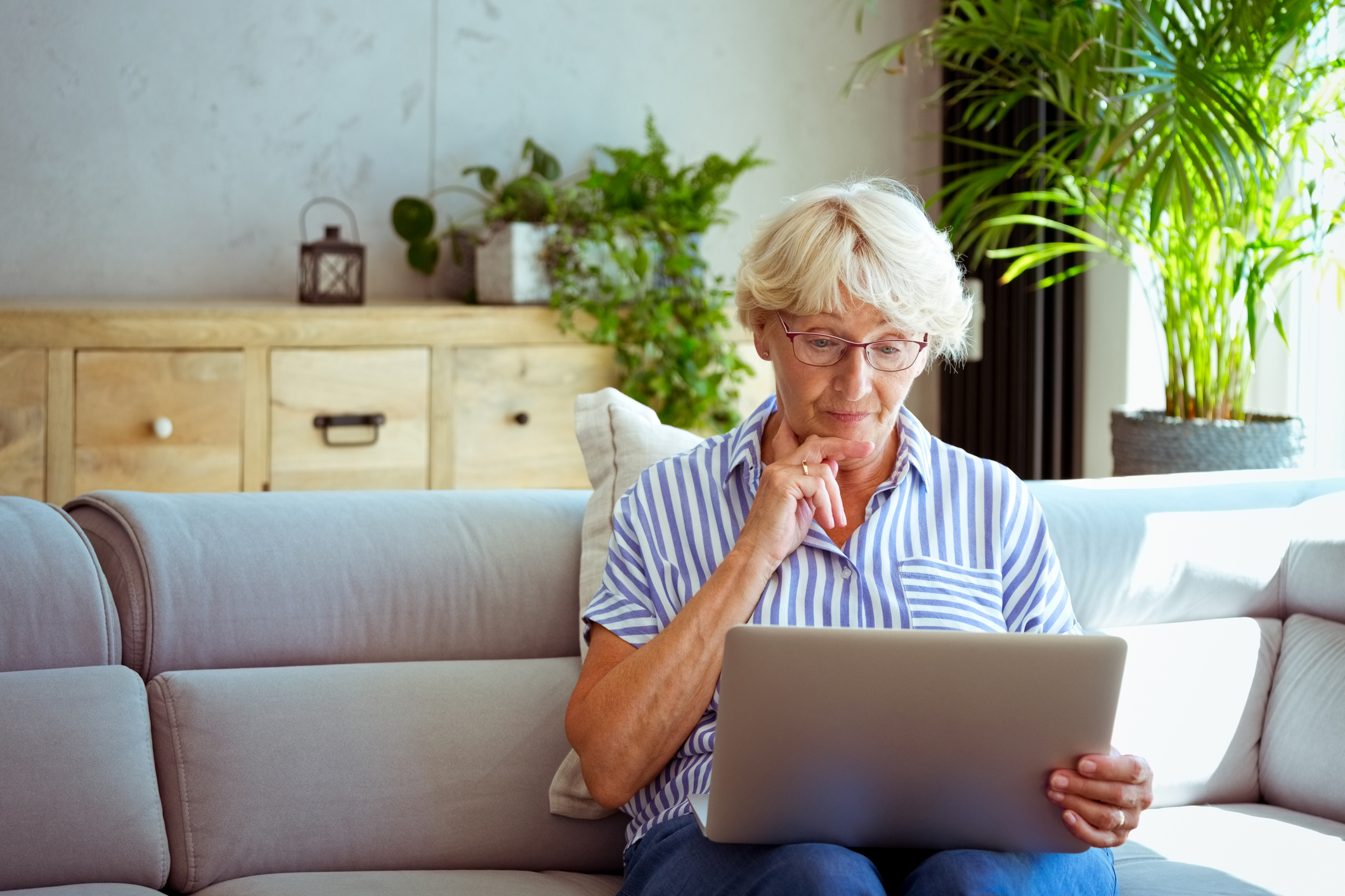 Uitkering in gevaar, vrouw kijkt bezorgd op laptop
