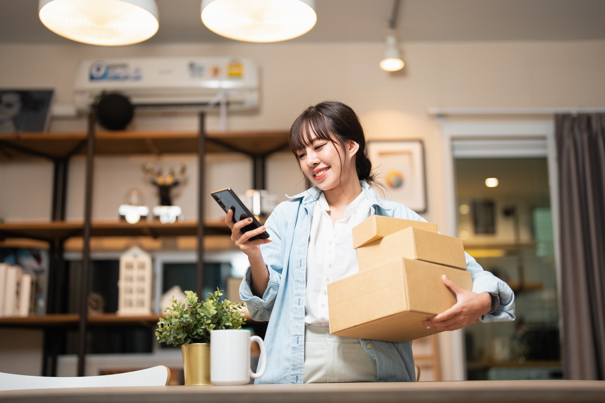 Chinese webwinkel vrouw met telefoon en pakjes