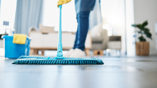 Schoonmaker doet de vloer met een mop