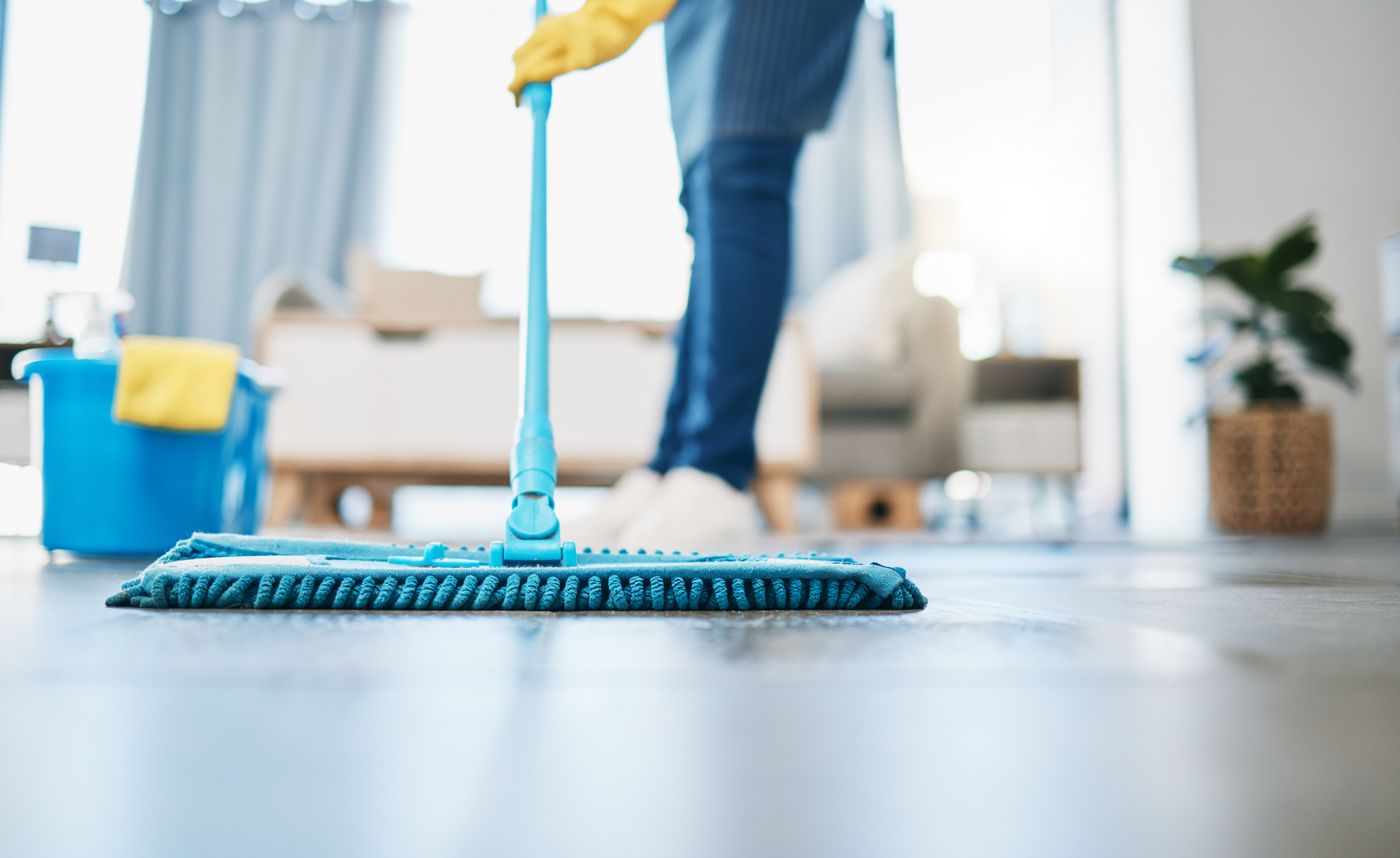 Schoonmaker doet de vloer met een mop