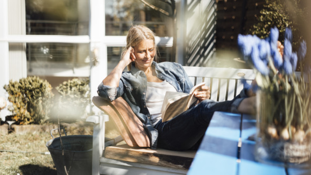 Vrouw leest boek in de tuin