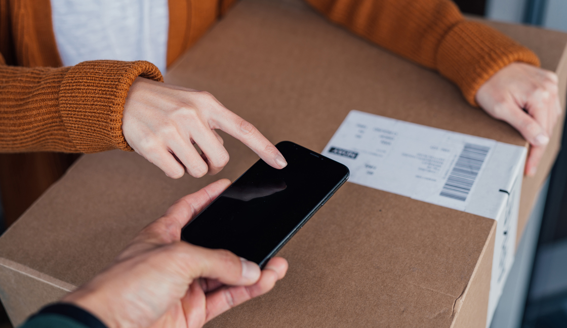 Young Woman Receiving And Signing For Delivery