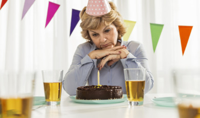 Vrouw viert verjaardag alleen met chocoladetaart, sip gezicht