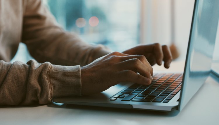 Iemand achter de laptop aan het werk