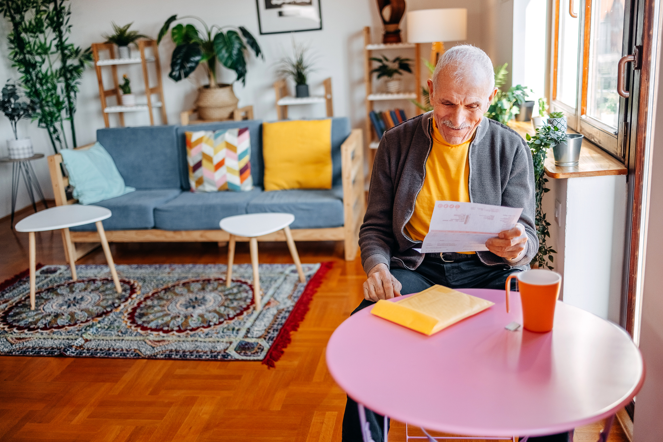 Man is thuis bezig met zijn financiele zaken, leest een brief