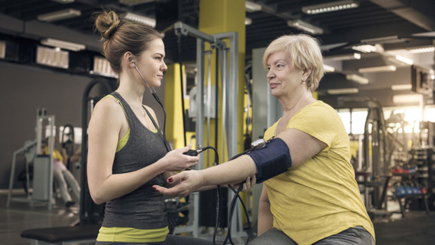 vrouw meet bloeddruk in sportschool