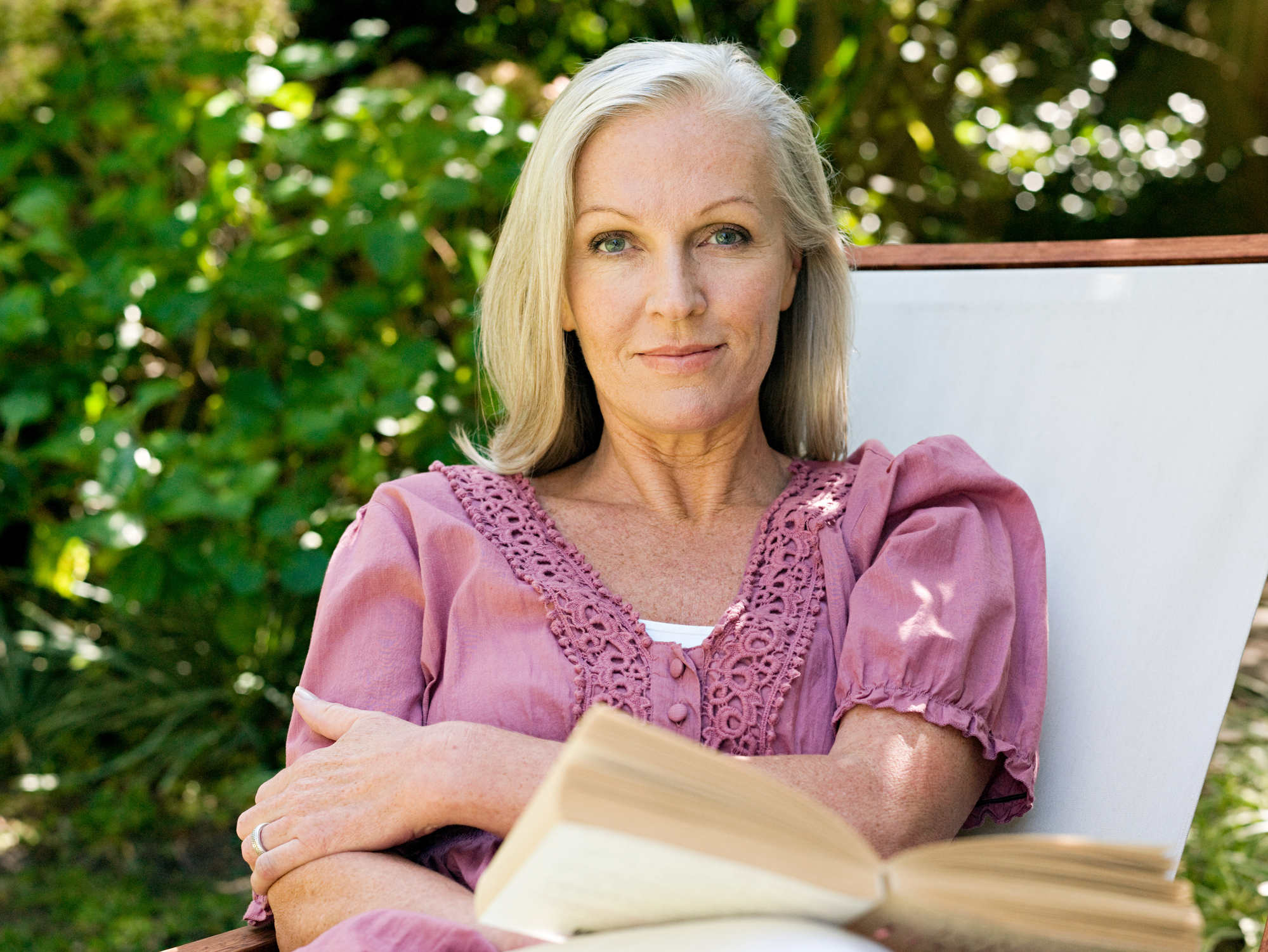 Vrouw leest boek in de tuin