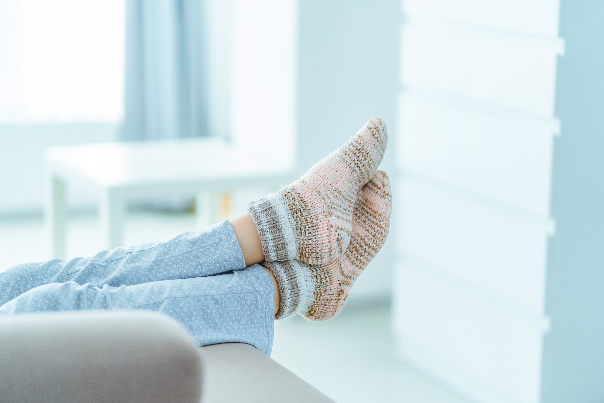 Vrouw met benen omhoog op de bank in warme sokken