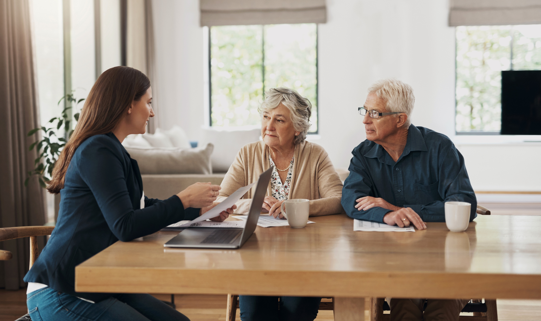 Makelaar in gesprek met senior stel aan de keukentafel