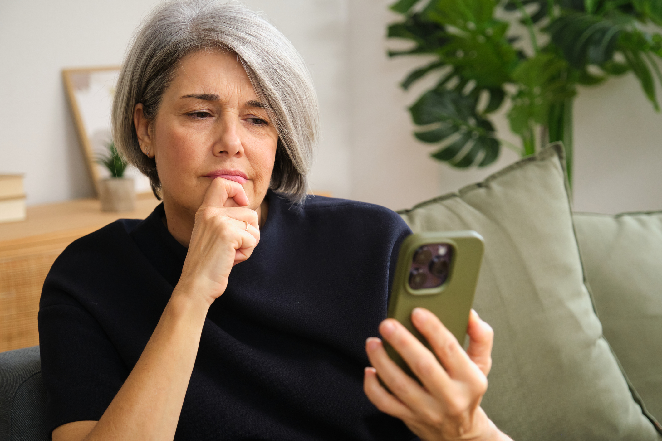 Vrouw checkt telefoon met bezorgd gezicht