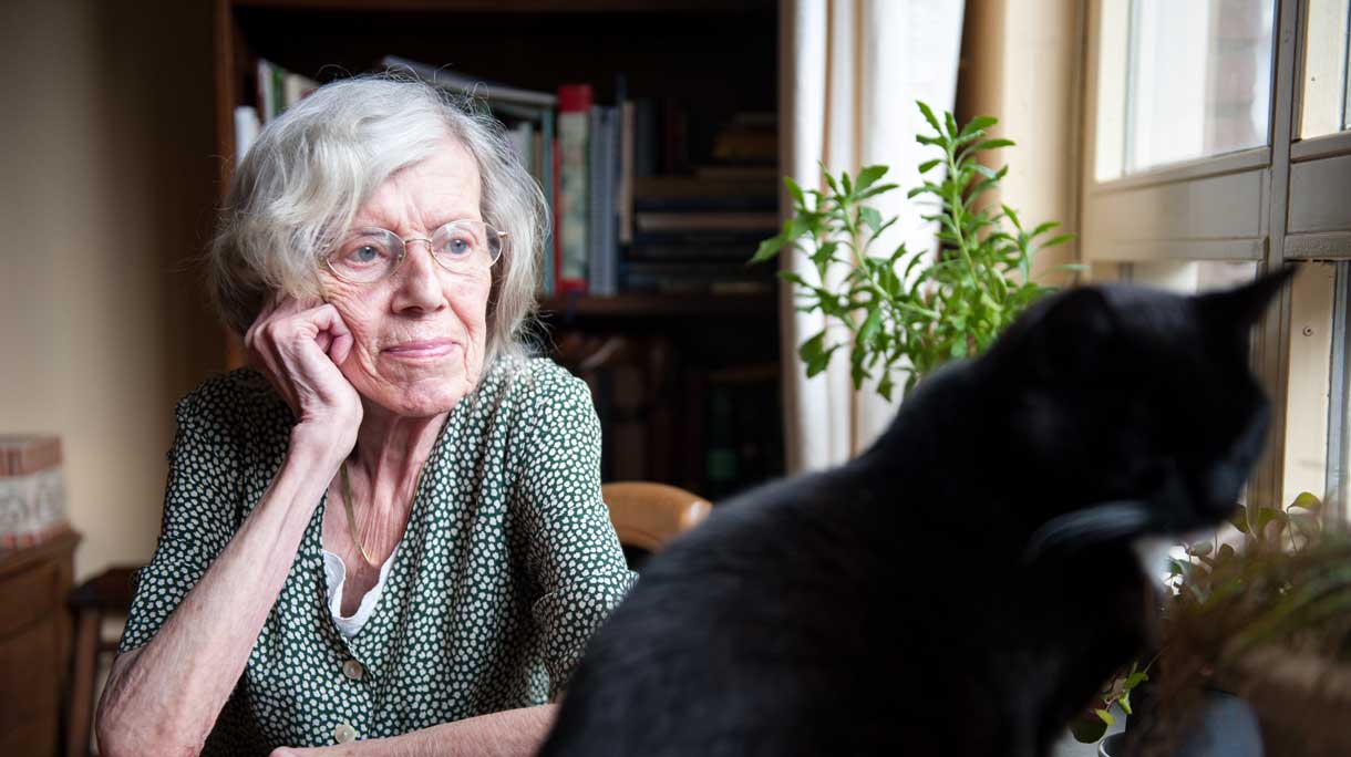 oudere vrouw staart uit raam