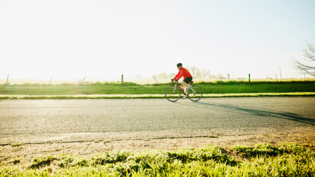 Sportieve senior aan het wielrennen op een mooie morgen