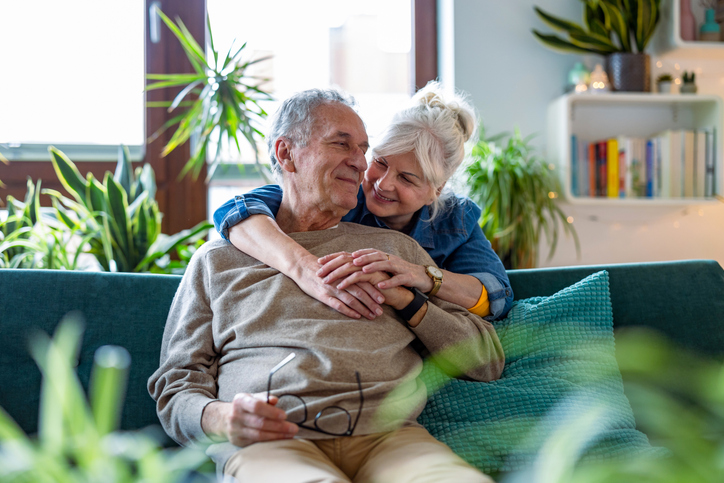 Ouder koppel knuffelt samen op de bank