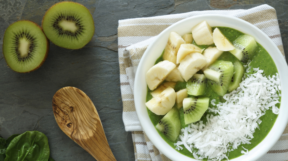 Green smoothie bowl with spinach, kiwi, bananas and coconut