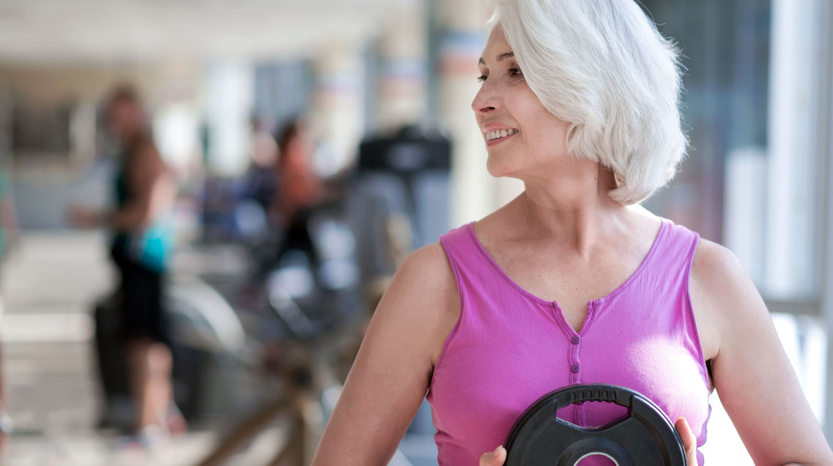 Delighted smiling woman exercising with sport equipment.