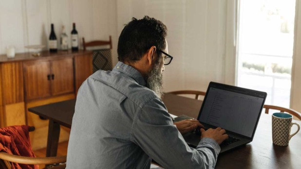 man achter laptop
