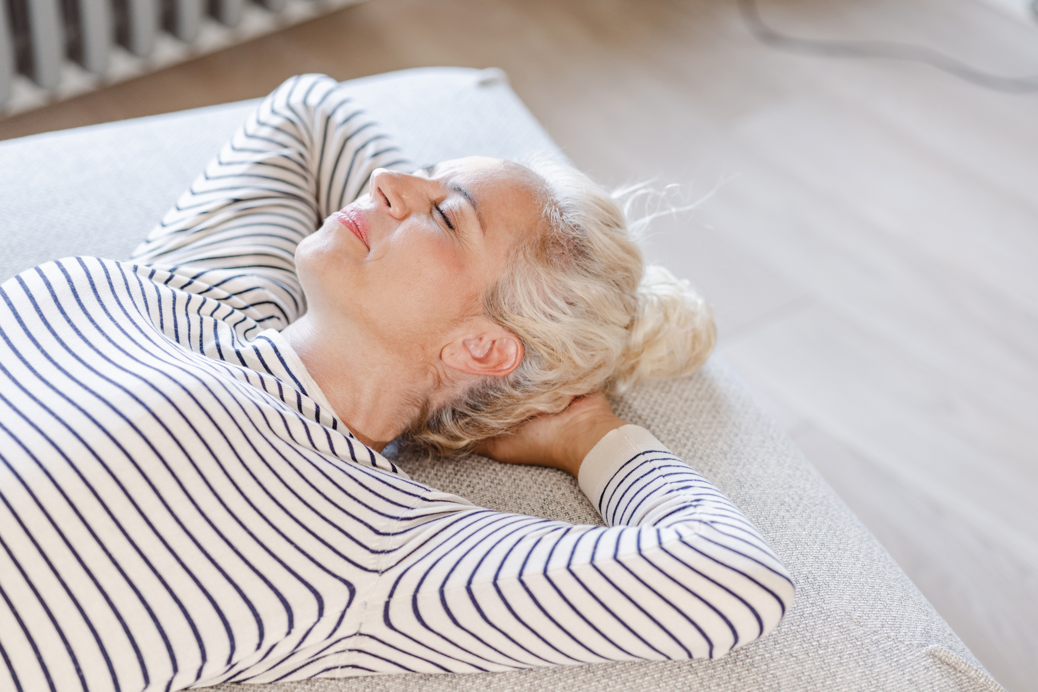 Vrouw ligt op haar rug zonder kussen op haar bed