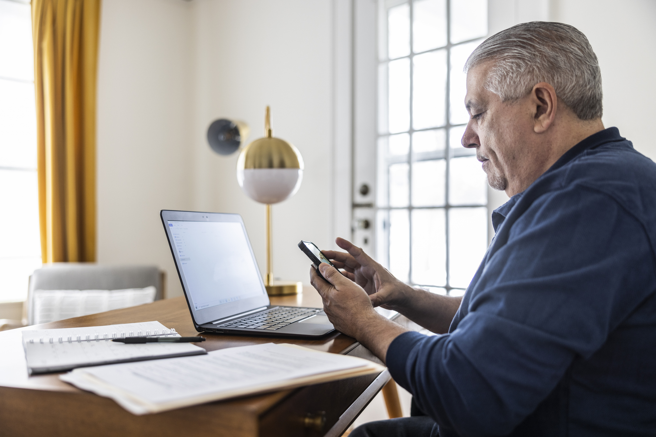 Corpulente man is thuis aan het werk achter zijn laptop