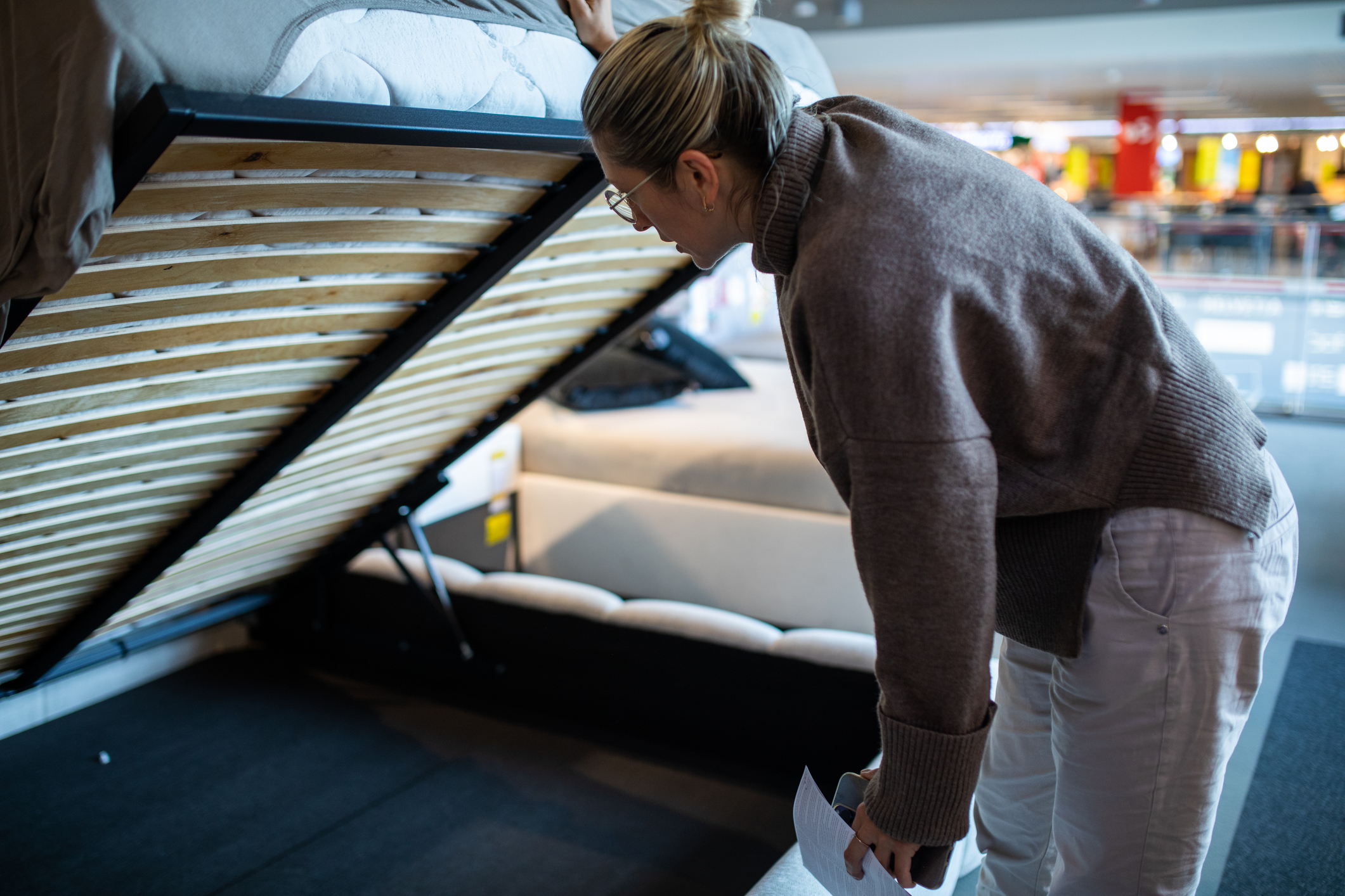 Vrouw kijkt naar lattenbodem in winkel voor bedden