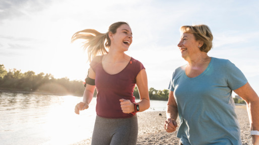 Moeder en dochter rennen in de zon met activity tracker om de pols